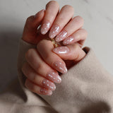 Close-up of hands with pink polish with polka dot art on a neutral background