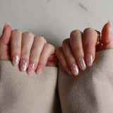 Close-up of hands with polished nails against a neutral background