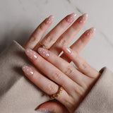Hand with pink nail polish and gold rings on a neutral background