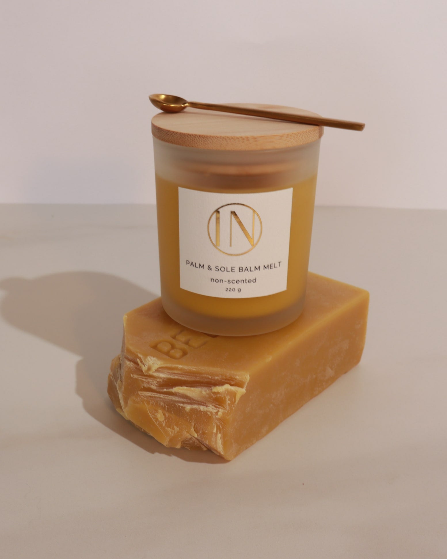 Palm and sole balm melt with a wooden container on a beige background