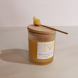 Jar of palm and sole balm with wooden applicator on a light background