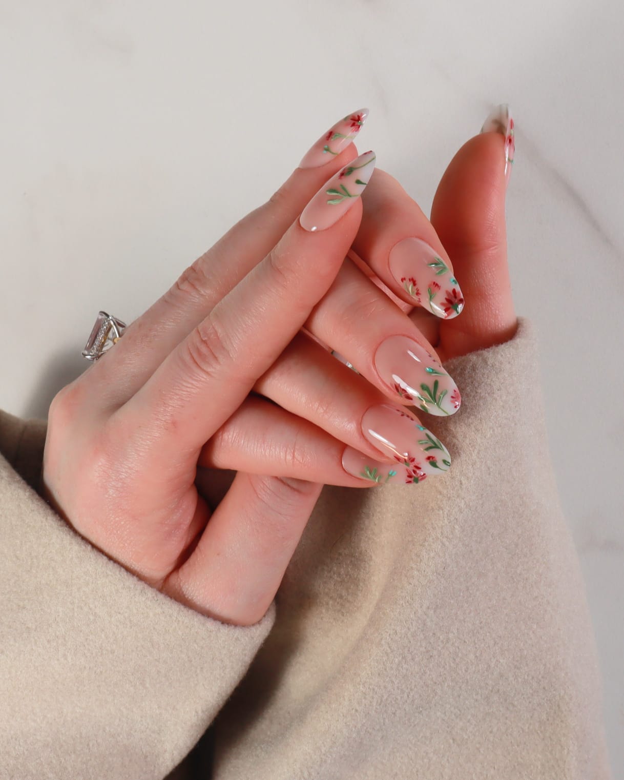 Hand with floral nail design on a neutral background
