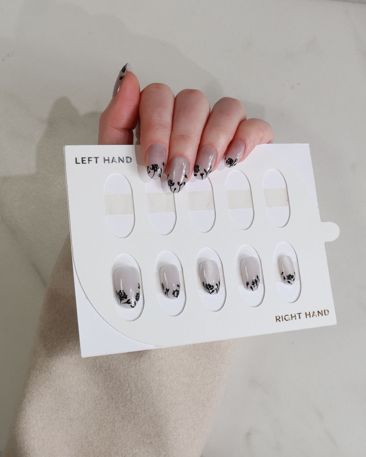 Nail art display card with nail designs held by a hand